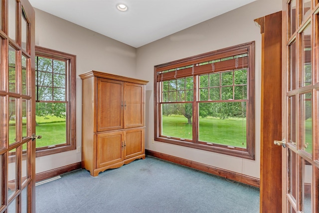 unfurnished room featuring plenty of natural light, light colored carpet, baseboards, and french doors