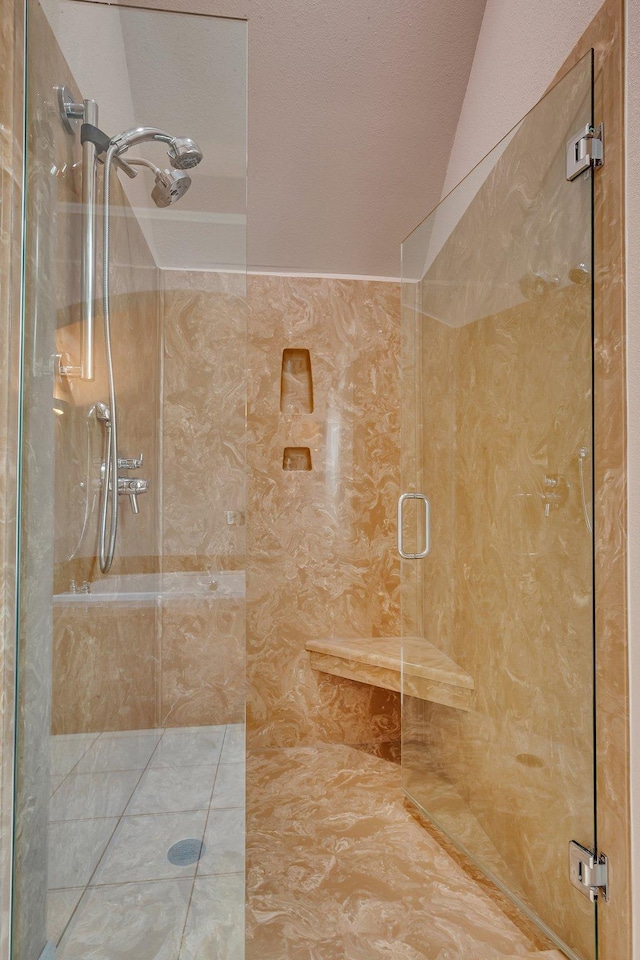 full bathroom with a textured ceiling and a stall shower