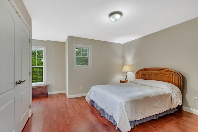 bedroom with baseboards and wood finished floors