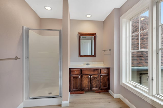 full bathroom with a healthy amount of sunlight, a stall shower, and baseboards