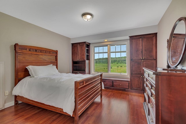 bedroom featuring dark wood-type flooring and baseboards