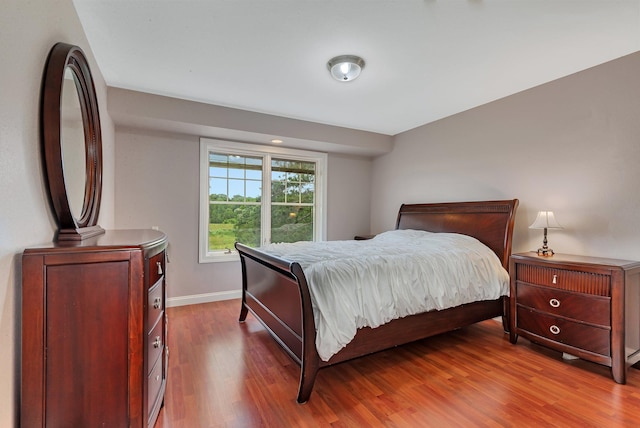 bedroom with baseboards and wood finished floors