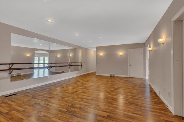 empty room featuring visible vents, baseboards, and wood finished floors