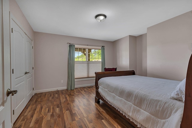 bedroom with wood finished floors and baseboards