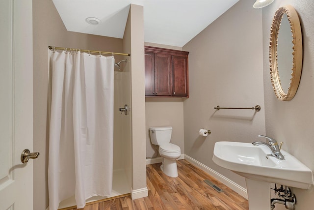 full bathroom with wood finished floors, visible vents, baseboards, curtained shower, and toilet