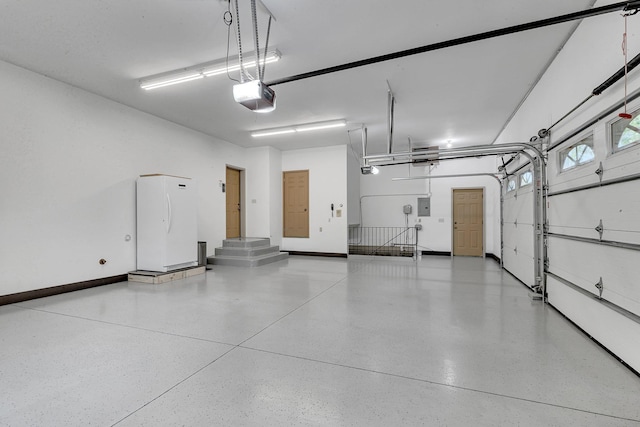 garage featuring freestanding refrigerator, baseboards, a garage door opener, and electric panel