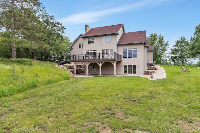 back of property featuring a lawn, a patio, a chimney, and a deck