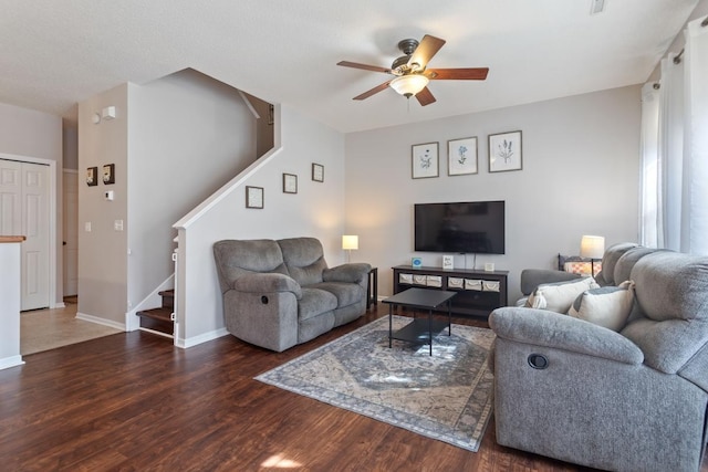 living area featuring wood finished floors, stairway, a ceiling fan, and baseboards