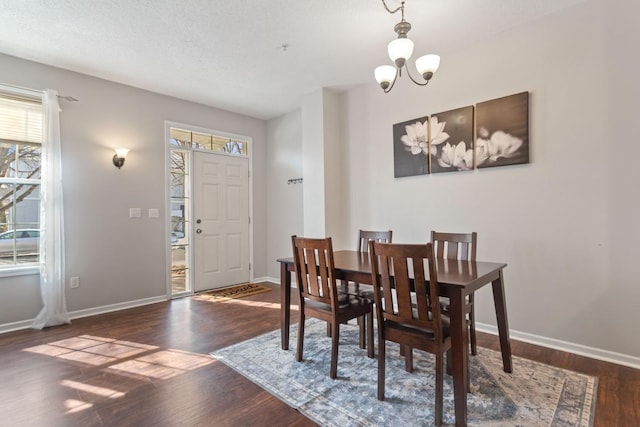 dining room featuring baseboards, a notable chandelier, and wood finished floors