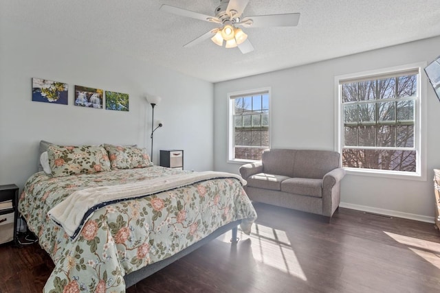 bedroom featuring a textured ceiling, a ceiling fan, baseboards, and wood finished floors