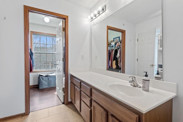 bathroom featuring tile patterned flooring, vanity, and baseboards