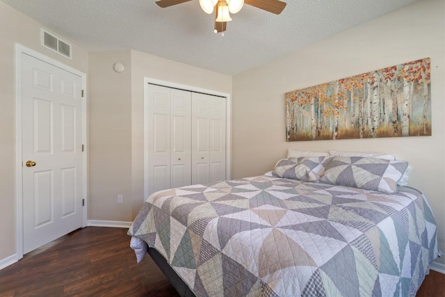 bedroom featuring wood finished floors, visible vents, ceiling fan, a closet, and a textured ceiling