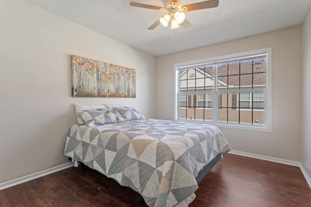 bedroom with ceiling fan, a textured ceiling, baseboards, and wood finished floors