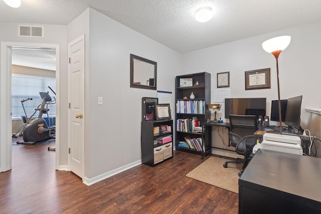 office area with visible vents, baseboards, dark wood-type flooring, and a textured ceiling