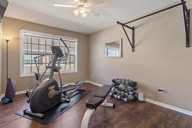 workout room featuring a textured ceiling, wood finished floors, baseboards, and ceiling fan