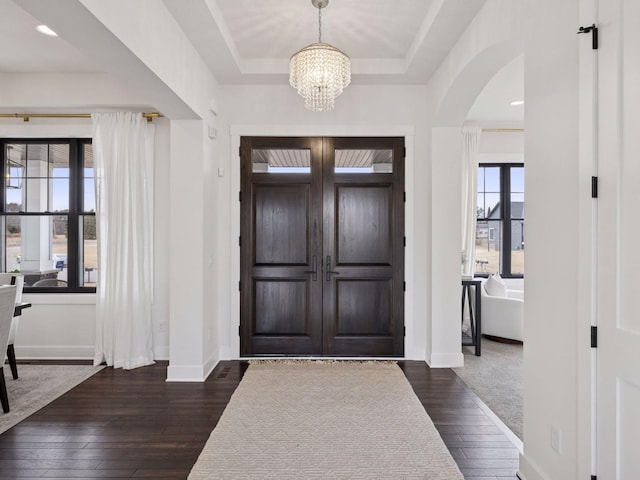 16419 Kiska St NE, Ham Lake, MN 55304 - entryway with arched walkways, a chandelier, dark wood-type flooring, and a tray ceiling