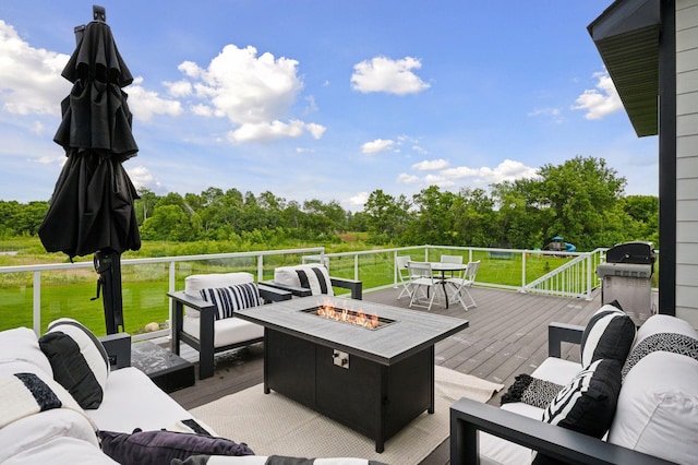 16419 Kiska St NE, Ham Lake, MN 55304 - deck featuring an outdoor living space with a fire pit, outdoor dining area, a yard, grilling area, and view of wooded area