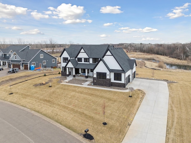 16419 Kiska St NE, Ham Lake, MN 55304 - view of front of home with concrete driveway, covered porch, board and batten siding, roof with shingles, and a water view