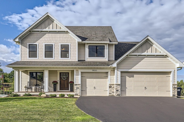 view of front of property with a front lawn, covered porch, board and batten siding, and driveway