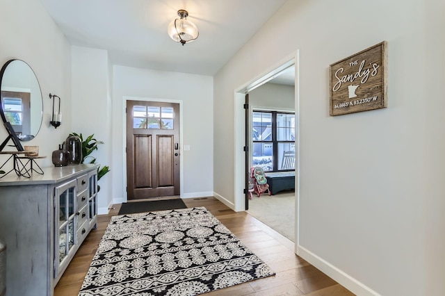 entryway with baseboards and wood finished floors