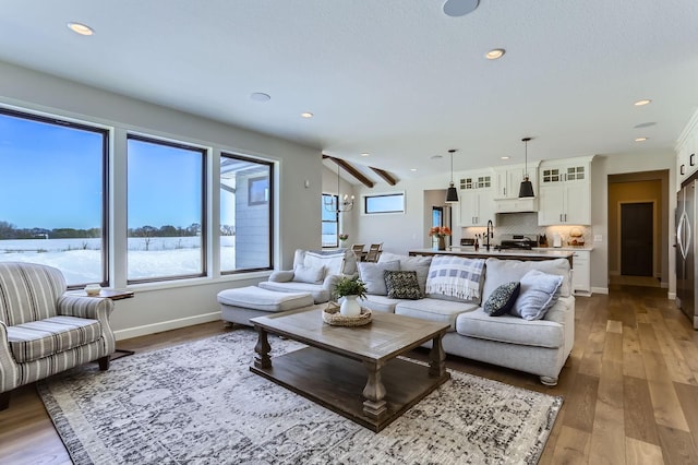 living area with recessed lighting, wood finished floors, and baseboards