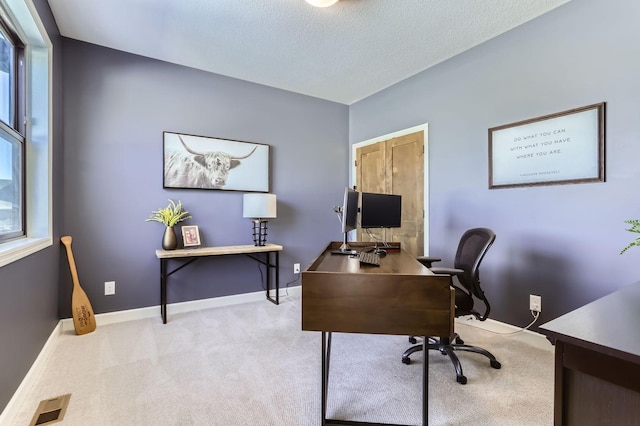 carpeted office space featuring a textured ceiling and baseboards