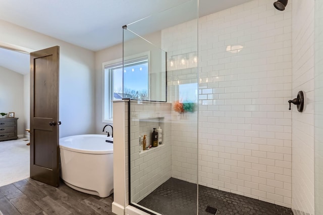 full bathroom with wood finished floors, a walk in shower, and a freestanding bath