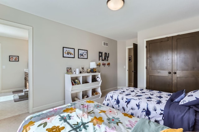 bedroom featuring a closet, visible vents, baseboards, and carpet floors