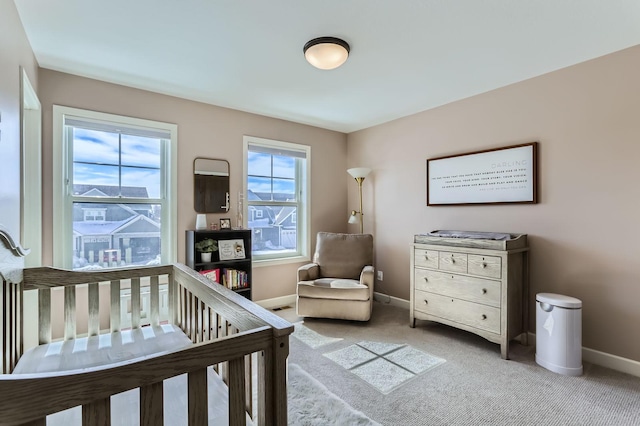 bedroom featuring light carpet, a nursery area, multiple windows, and baseboards