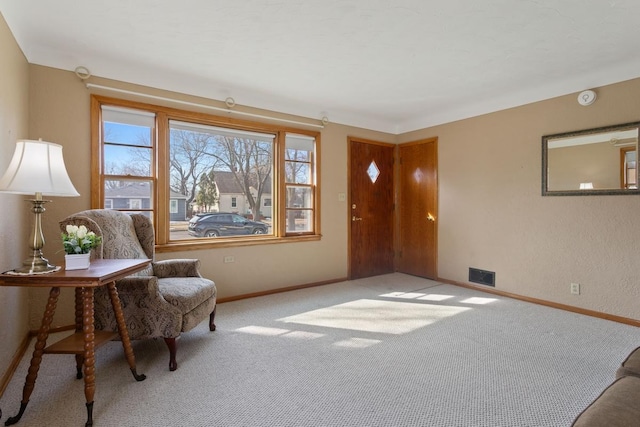 living area with visible vents, baseboards, and carpet