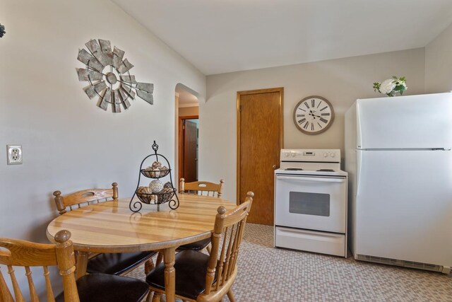 kitchen featuring arched walkways and white appliances