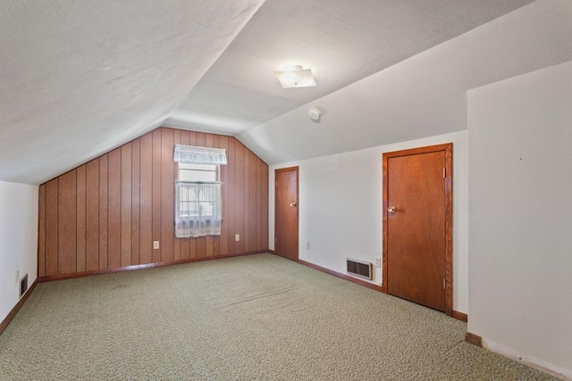 bonus room with visible vents, a textured ceiling, carpet, and vaulted ceiling