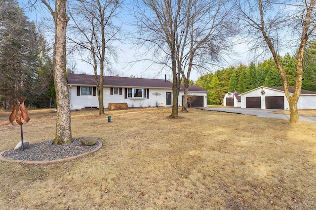 single story home featuring a garage, an outbuilding, and a front yard