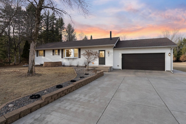 ranch-style house featuring a garage and driveway