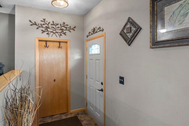 entrance foyer featuring baseboards and a textured ceiling