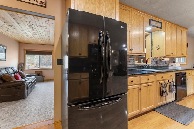 kitchen with open floor plan, black appliances, light wood-style floors, and a sink