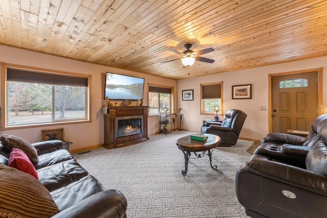 carpeted living area featuring a glass covered fireplace, wooden ceiling, and baseboards