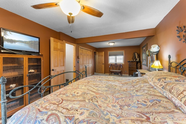 bedroom with ceiling fan and a textured ceiling