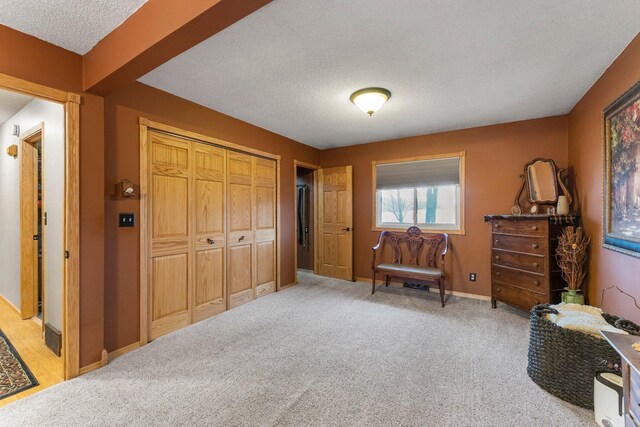 bedroom with baseboards, a closet, carpet floors, and a textured ceiling