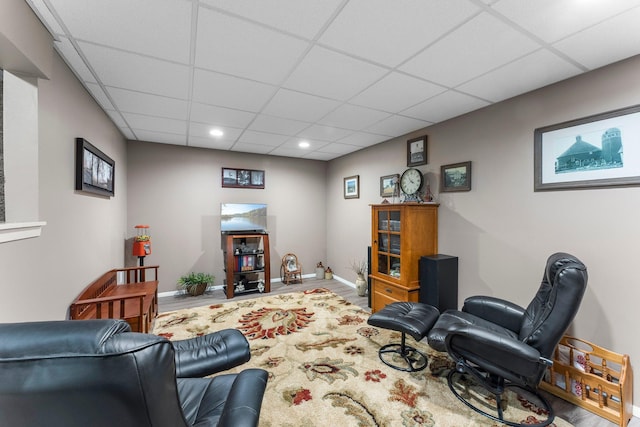 living room featuring recessed lighting, a drop ceiling, baseboards, and wood finished floors