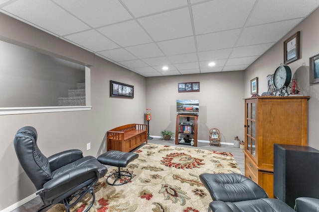 living area with recessed lighting, a paneled ceiling, and baseboards