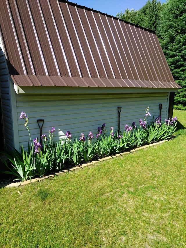 view of side of home featuring a yard and metal roof