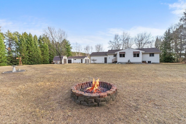 view of yard featuring an outdoor structure, a shed, and an outdoor fire pit