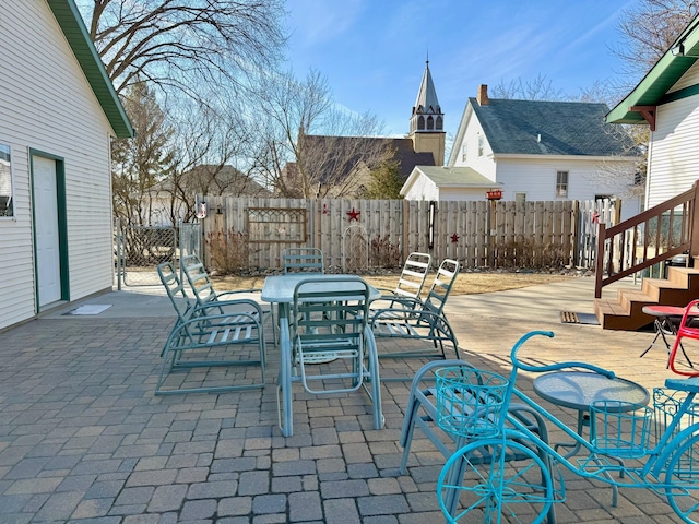 view of patio featuring outdoor dining space and fence