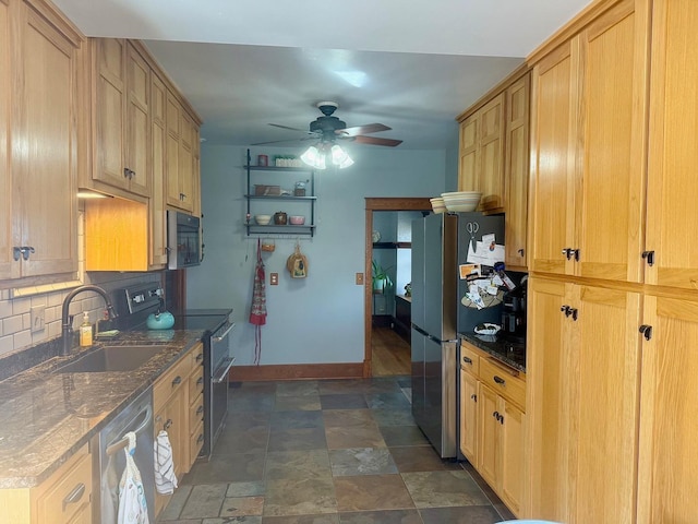 kitchen featuring baseboards, ceiling fan, decorative backsplash, a sink, and appliances with stainless steel finishes