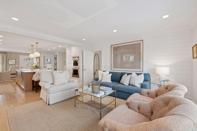 living area featuring light wood-style flooring, recessed lighting, and ornamental molding