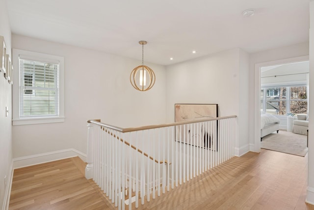 hall with wood finished floors, recessed lighting, an upstairs landing, and baseboards