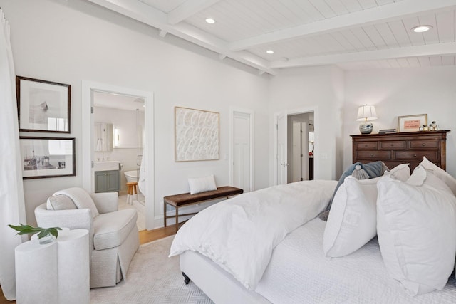 bedroom with recessed lighting, connected bathroom, light wood-style flooring, and vaulted ceiling with beams