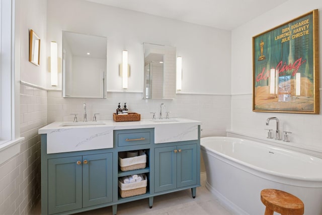 full bath featuring a soaking tub, tile walls, tile patterned floors, and a sink