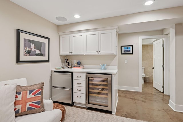 bar featuring beverage cooler, recessed lighting, a dry bar, and baseboards